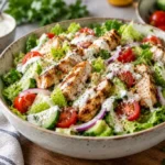 finished ranch chicken salad in a bowl with grilled chicken, tomatoes, cucumber and ranch dressing